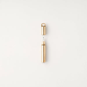 Tom's Studio Field Mouse pen in Brass, uncapped with brass loop cap above, on textured white background