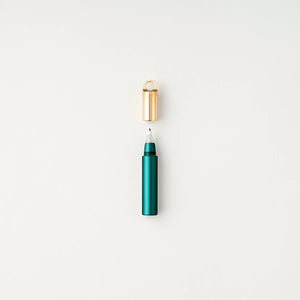 Tom's Studio Field Mouse pen in Ivy (dark green), uncapped with brass loop cap above, on textured white background