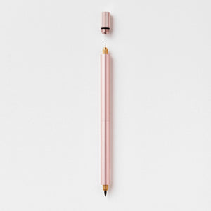 Tom's Studio Lumos Pro Duo in Rose Gold (soft pink), fineline and brush tips exposed, cap shown above, on textured paper